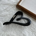 Macro shot of matte black heart-shaped hair claw with gold Barrette La France lettering - Black Heart Label 13cm