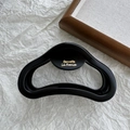 Detailed macro view of matte black hair claw clip with gold Barrette La France text - Black Semicircle Label 12cm