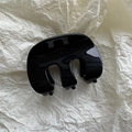 Primer plano de la pinza para el pelo de resina negra brillante sobre fondo de papel beige - Negro