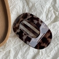 Detail view of tortoiseshell claw clip with acetate finish on white textured background - Grey Coffee Leopard