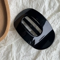 Detail of glossy black geometric hair claw clip on minimalist paper background - Bright Black