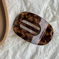 Macro detail of tortoiseshell leopard print hair claw clip with smooth polished finish - Yellow Coffee Tortoise