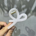 Detail of a light pink translucent M-shaped hair claw with gold metal spring - 8cm Small Bowknot / Fruit White