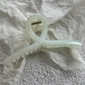 Close-up of mint green starfish hair claw clip with subtle glitter on textured paper - Starfish Green Crossover (13cm)