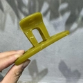 Close-up of olive green semi-transparent claw clip with square cutout design - 10cm T-Shape / Yellow-Green