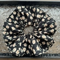 Detail eines großen schwarzen Chiffon-Haargummis mit floralem Muster und Rüschen-Lagen - Schwarz