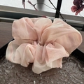 Detailansicht eines rosa Haargummis aus Chiffon auf einem eleganten Tablett - Rosa Tuschemalerei