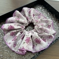 Close-up of floral scrunchie with purple rose patterns and wave edges on a black tray - Pink Purple Floral Large
