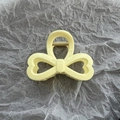Detalle de una pinza para el pelo amarillo crema en forma de lazo con muelle de metal dorado - Amarillo
