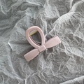 Top view of a glossy light pink bow hair claw clip on textured grey paper - Small Korean Pink