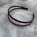 Detail showing two slim non-slip headbands in black and burgundy with inner teeth - Black and Red