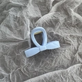 Close-up of a light blue bow-shaped hair claw clip with a durable gold metal spring - Small Sky Blue