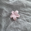 Detail view of a pink marble-textured frangipani hair claw clip with gold metal grip - Pink