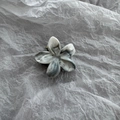 Macro shot of marble textured flower hair claw clip with grey acetate finish and metal spring - Grey/White
