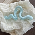 Detail der eisblauen gewellten Haarklammer mit Marmortextur und einer silbernen Feder - Blau