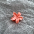 Close-up of pink marble texture frangipani flower hair claw with acrylic finish - Orange