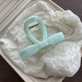 Close-up of mint green marble bow hair claw clip with golden metal spring details - Green