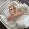 Detail view of peach marble textured ribbon hair claw clip with golden metal spring - Brown