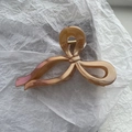 Detail der eleganten Haarklammer in Champagner-Gold mit perlmuttartigem Finish - Karamellbraun