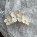 Dettaglio di un grande fermaglio per capelli in resina con design a tre fiori di plumeria - Bianco Triplo Fiore Marmo