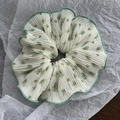 Close-up of a large white floral pleated scrunchie with green wavy edges and rose pattern - Green