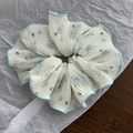 Dettaglio dell'elastico per capelli a fiori blu in chiffon plissettato con bordo blu - Blu