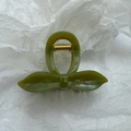 Detail of olive green resin hair claw clip with bow design and gold metal spring mechanism - Fruit Green