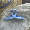 Detail of light blue macaron hair claw clip with silver spring on white paper background - Blue