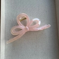 Detail of light pink mermaid bow hair claw clip with pearlescent finish and gold spring - Pink