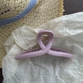 Detail of a matte lavender hair claw clip with a gold spring on summer holiday background - Pink