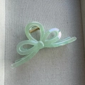 Detail of mint green iridescent bow hair claw clip with pearlescent translucent finish - Green