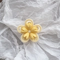 Detailansicht einer matten 3D-Tulpen-Haarklammer mit gelben Blütenblättern auf Seidenpapier - Milchgelb