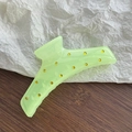 Detail of neon green shark hair claw clip with sparkling rhinestones on wooden desk - Light Green