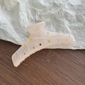 Detailed macro of a pale pink translucent hair claw clip with colorful rhinestones - Snow Bud White