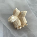 Detalle de pinza para el pelo con flor crema y textura marmolada sobre fondo de gasa blanca - Pinza de Flor Sólida