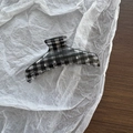 Detail view of a glossy black and white plaid hair claw clip with a durable metal spring - Black Plaid Long Curved