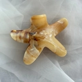 Detail view of starfish hair claw clip with amber marble texture on soft white fabric - Starfish Shape