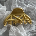 Detail of cross-woven design on cream yellow hair claw clip over white background - Yellow