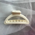 Macro detail of large matte cream hair claw clip with sturdy teeth on white tulle fabric - White Semi-Circle