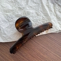Close-up of a large amber tortoiseshell hair claw clip with smooth glossy finish - Tortoiseshell