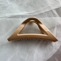 Close-up of soft silicone shark hair claw clip in tan color with triangle hollow design - Milk Coffee Triangle