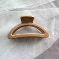 Close-up of soft khaki silicone hair claw clip with interlocking teeth for hairstyling - Milk Coffee Semi-circle