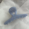 Detail of grey-blue hair claw clip with triangle hollow design on soft white fabric - Light Blue