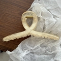 Detail view of large marbled hair claw clip with golden metal spring on wooden surface - Champagne Dual-Tone