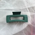 Detail view of a dark green square soft silicone hair claw clip on white tulle fabric - Dark Green Square