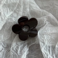 Close-up of a glossy black flower hair claw clip with a hollow center and petal details - Solid Dark Coffee