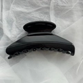 Primer plano de una pinza para el pelo negra brillante con dientes antideslizantes y muelle - Negro Brillante