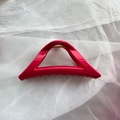 Close-up of bright rose red triangle hair claw clip with golden metal spring - Red Triangle