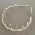 Gros plan des dents ondulées antidérapantes sur un serre-tête en plastique transparent - Motif Fluide Champagne