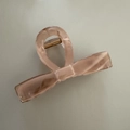 Dettaglio macro della molletta per capelli a fiocco rosa pesca con molla in metallo dorato - Fiocco Marmo Caffè